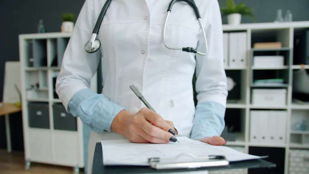 Doctor completing documentation on a clipboard